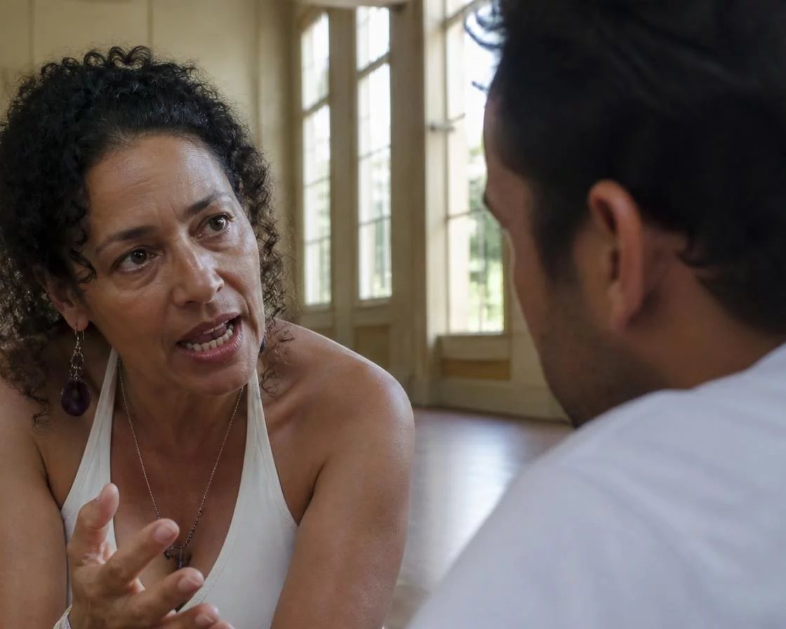 Pessoa em pé diante da turma sustentando um argumento com as anotações na mão
